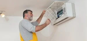 foto de homem mexendo no ar condicionado