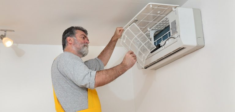 foto de homem mexendo no ar condicionado