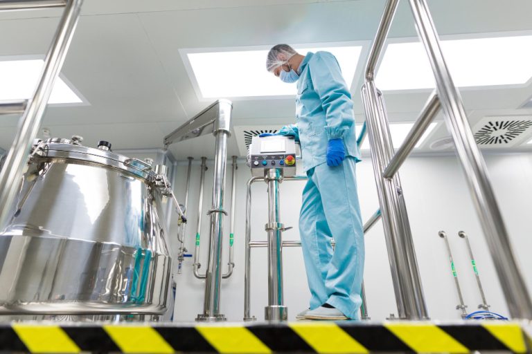 Filtro para laboratórios químicos: cientista com traje de laboratório usando painel de controle próximo a tanque de aço