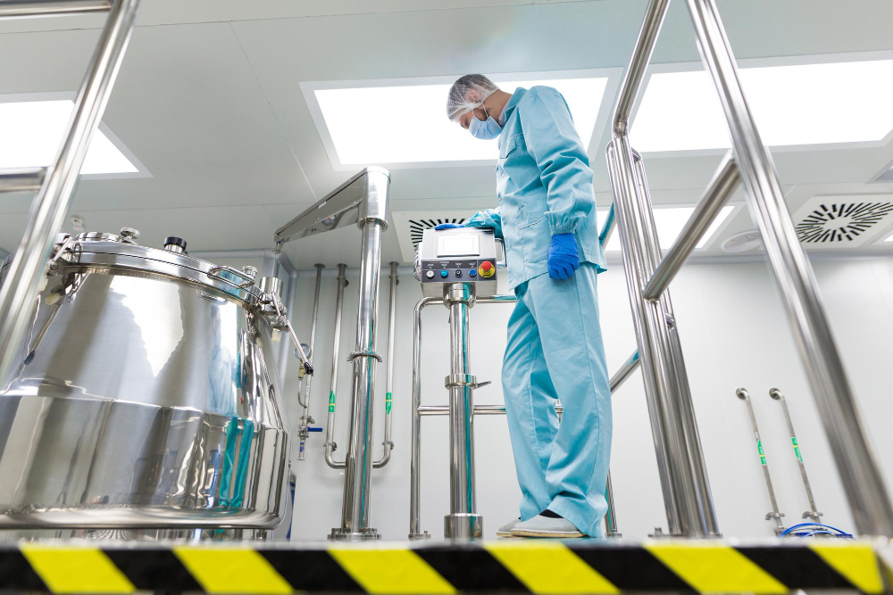 Filtro para laboratórios químicos: cientista com traje de laboratório usando painel de controle próximo a tanque de aço