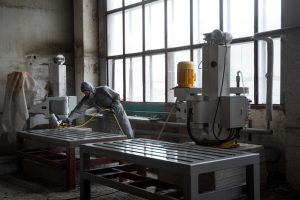 Retrabalho interno da indústria: homem em local de pintura com roupa e equipamento apropriados.