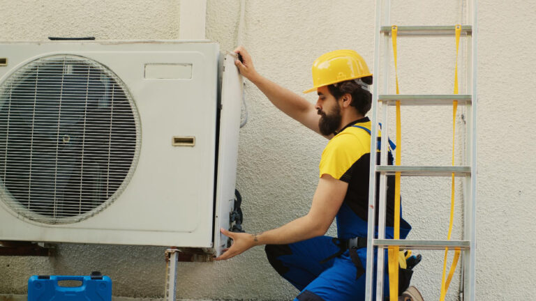 Mitos e verdades sobre o consumo de energia do ar condicionado técnico realizando manutenção.